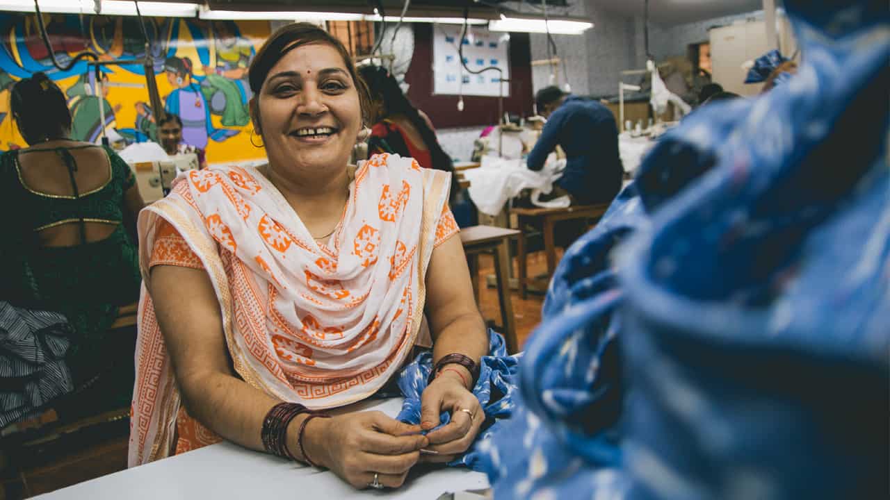 Woman finishing garments - Creative Handicrafts fair trade