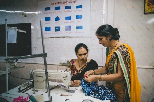 Teaching a trainee to sew at Creative Handicrafts