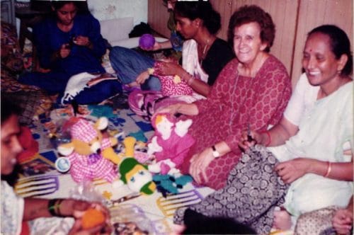 Sister Isabel working with women sewing toys