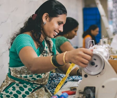 Woman sewing fair trade garments at Creative Handicrafts